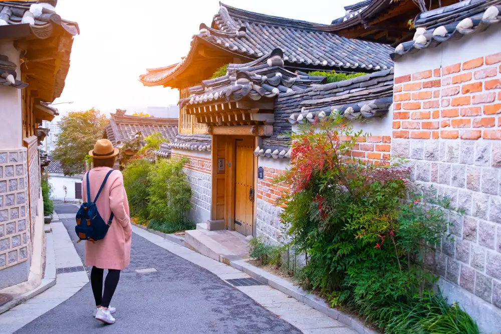 Young female international student walking safely on a busy street in Seoul, showing safety in Seoul.